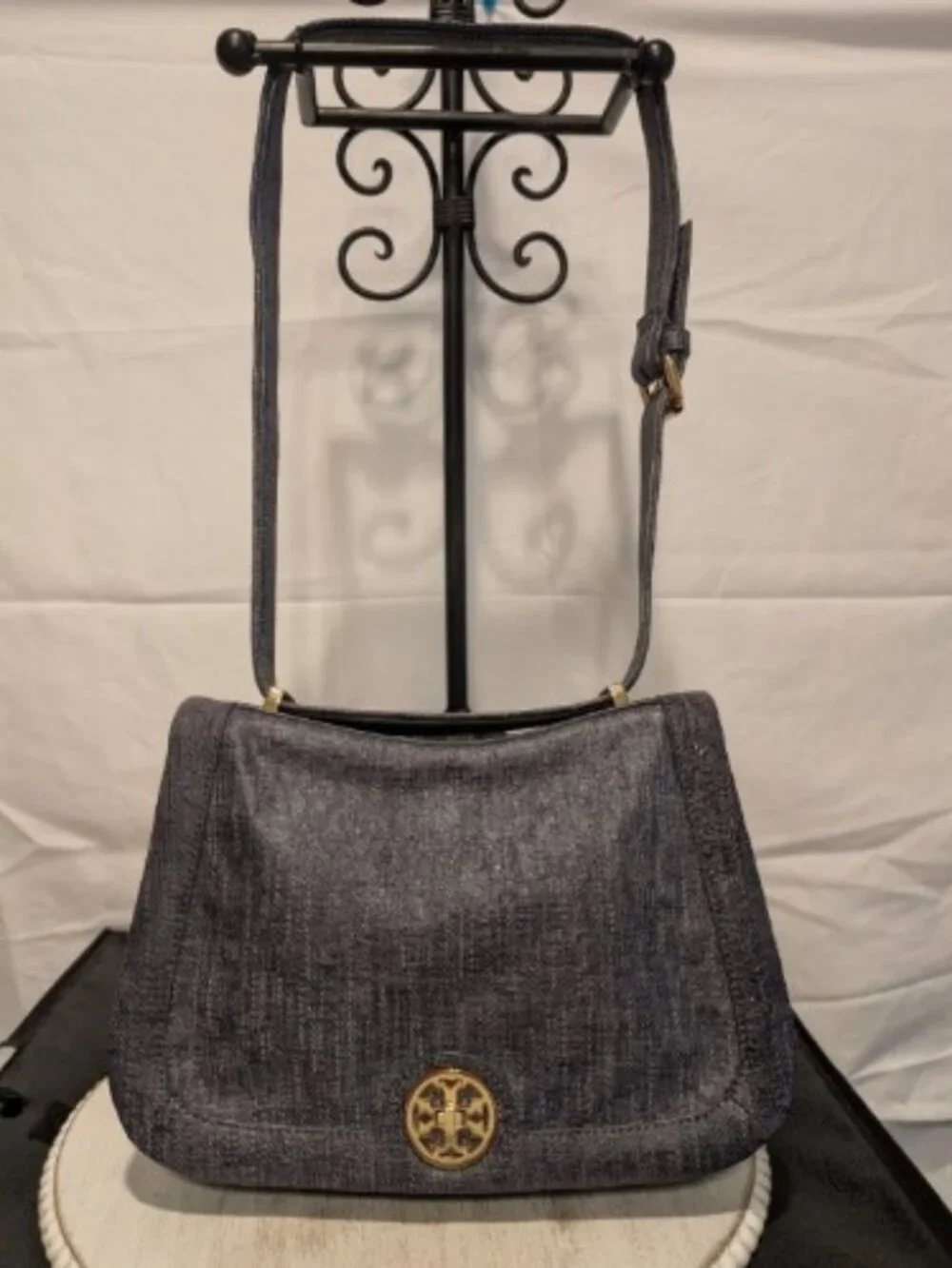 The Tory Burch Saddle Bag with Turn Lock in navy with a Brushed Denim Effect is